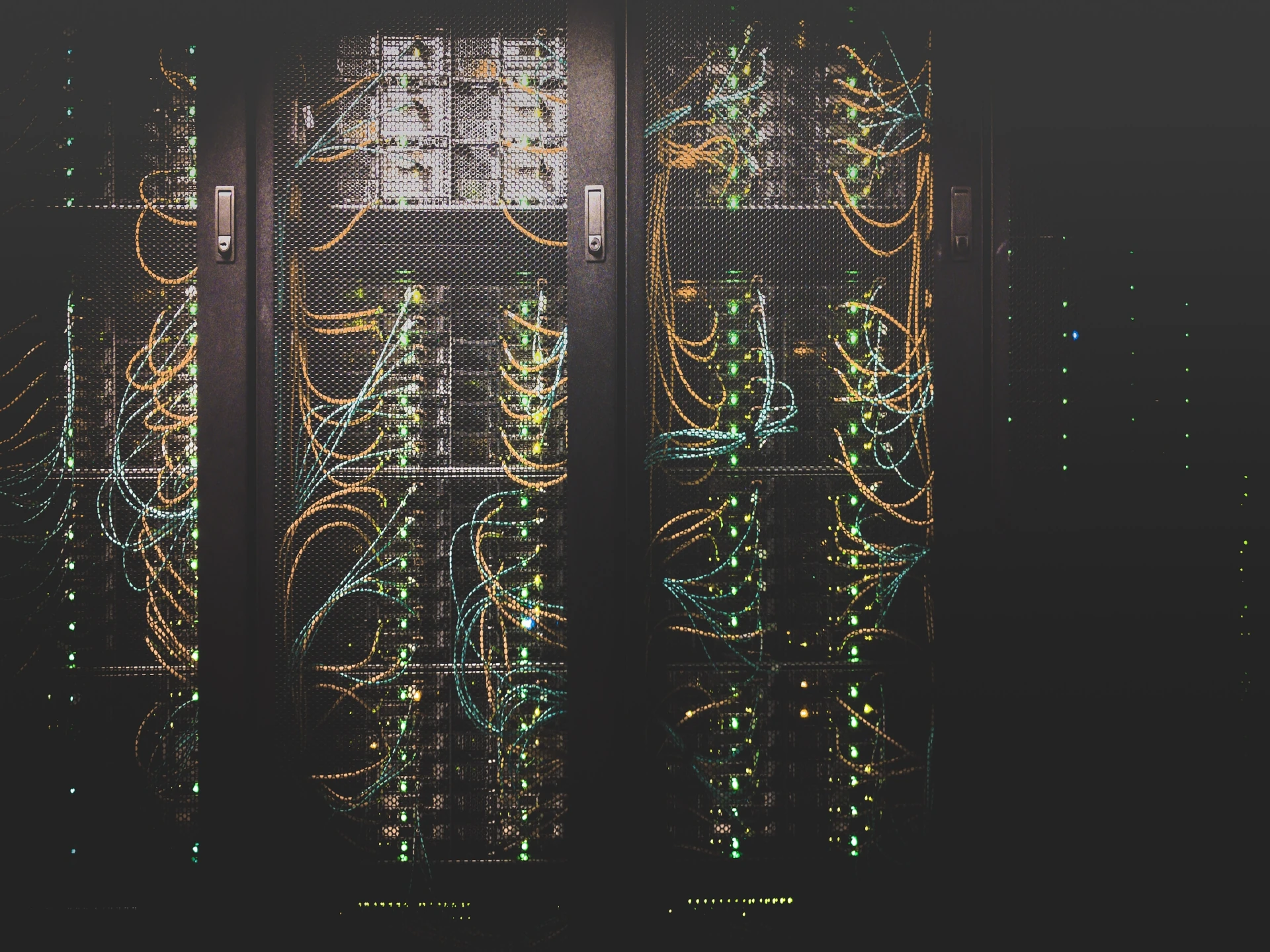 Centre de données avec des rangées de baies de serveurs et des câbles réseau